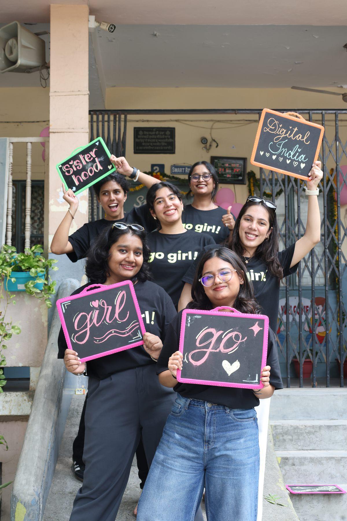 Go Girl team holding hand-lettered signs