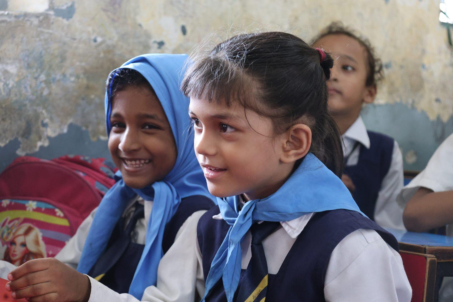 Two young students smiling in class